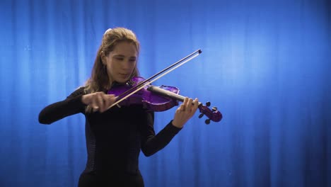 Young-musician-woman-playing-violin-on-stage.